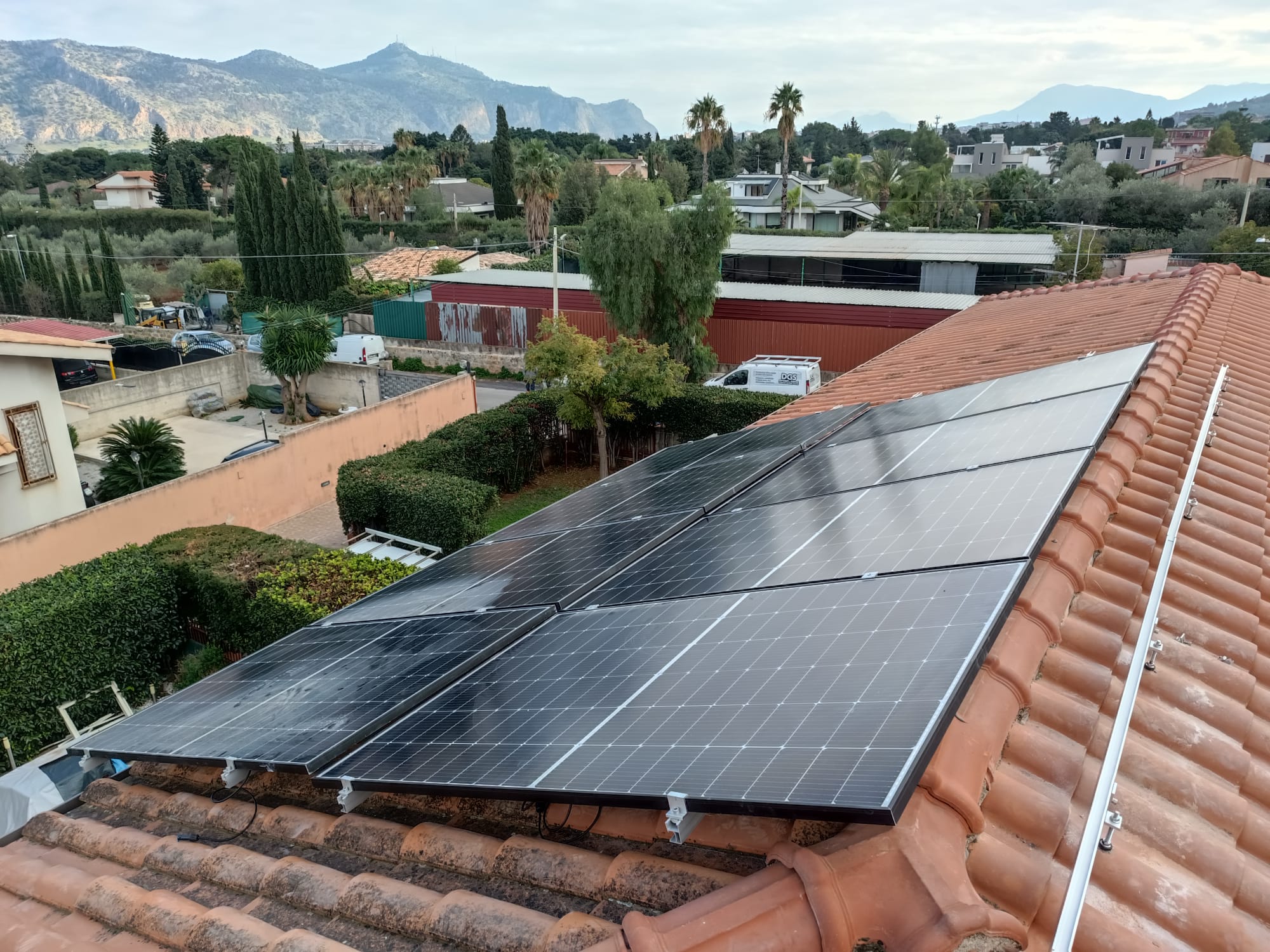 Impianto fotovoltaico realizzato da Futuro Immobiliare su tetto in tegole, con panorama sullo sfondo